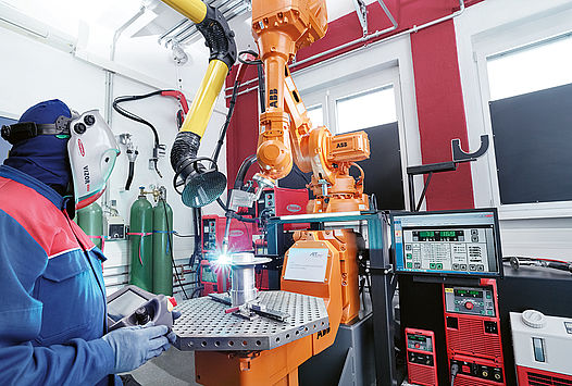 researcher works on a machine in the additive manufacturing laboratory