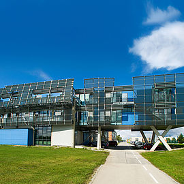 modernes Gebäude vor blauen Himmel und mit Rasen davor