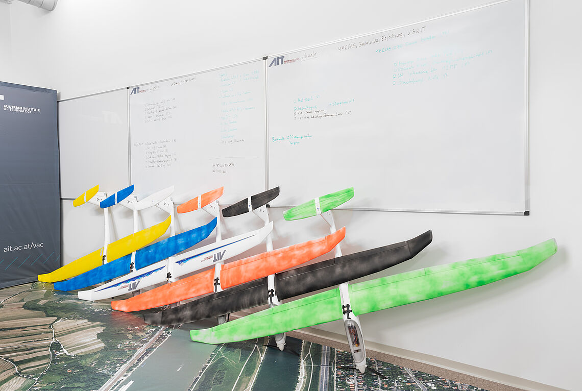 Verschiedenfärbige Modellflieger aufgestellt an der Wand im AIT Fluglabor