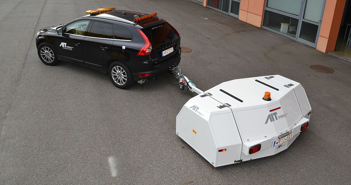 black car with an a white trailer that is wider than the car and about half the length