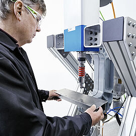 scientist working with a self piercing rivet machine