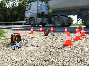 Erschütterungsmessung auf dem Boden unter einer Straße, wo ein LKW drüber fährt