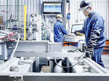 vertical continuous casting line with employees in front