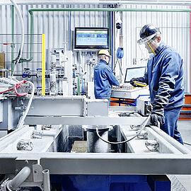 vertical continuous casting plant with employees working on it