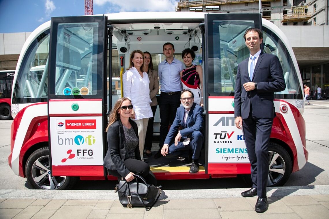 Autonomer E-Bus mit dem ein Gruppenfoto gemacht wird