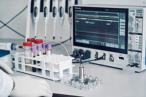 Laborumgebung mit Blutproben, Prototyp-Chip und Daten-Monitor